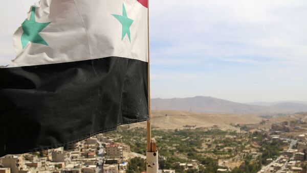 In this photo taken on Sunday, Oct. 18, 2015, a Syrian flag flies above the village of Maaloula, north of Damascus, Syria - Sputnik Mundo