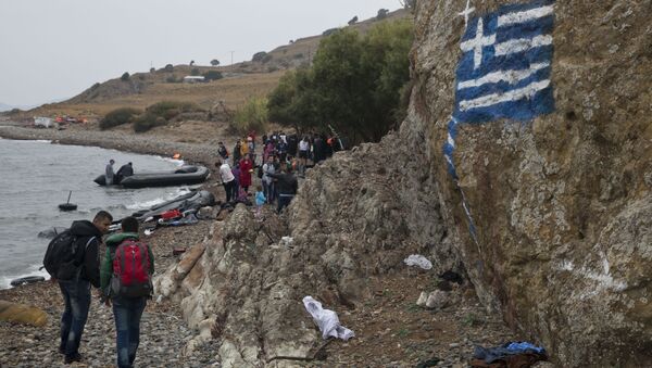 La bandera de Grecia pintada en la roca, los migrantes llegando a las orillas de la isla griega de Lesbos, Sept. 22, 2015 - Sputnik Mundo
