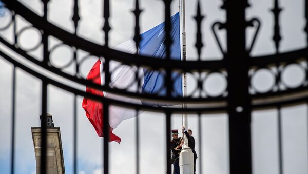 A Republican Guard lowers the French national flag at half-mast at the Elysee Palace in Paris - Sputnik Mundo