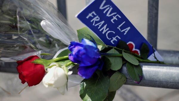 Flowers are seen attached to a fence to remember the victims of the Bastille Day truck attack in Nice in front of the French embassy in Rome. - Sputnik Mundo