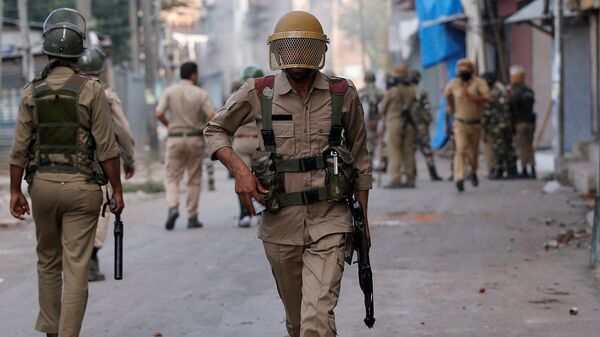 An Indian policeman runs during a protest in Srinagar against the recent killings in Kashmir - Sputnik Mundo