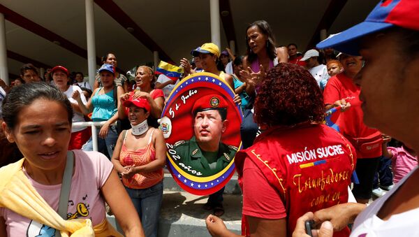 Gente con el retrato del fallecido presidente Hugo Chávez  en Caracas, Venezuela - Sputnik Mundo