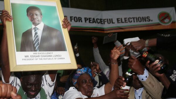 El retrato de reeligido presidente de Zambia, Edgar Lungu, en las manos de sus partidarios - Sputnik Mundo
