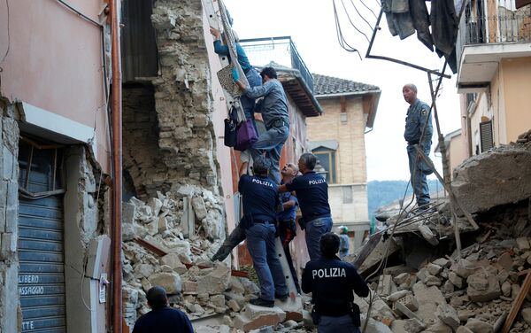 Policía ayuda a una mujer tras el sismo en Amatrice, Italia - Sputnik Mundo