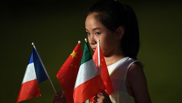 Una niña sostiene las banderas de los países miembros del G20 en la cumbre en Hangzhou - Sputnik Mundo