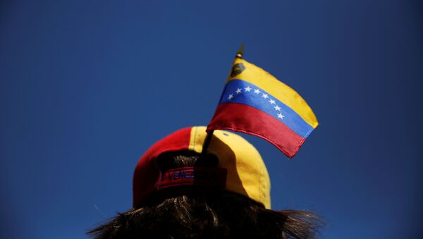 A protester carries a Venezuelan flag on her cap during a demonstration to demand a referendum to remove Venezuela's President Nicolas Maduro, in Madrid, Spain, September 4, 2016. - Sputnik Mundo