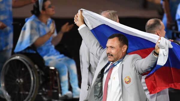 Un miembro de la selección paralímpica bielorrusa lleva la bandera de Rusia durante la ceremonia de inaugaración de los Juegos Paralímpicos de 2016 en Río de Janeiro - Sputnik Mundo