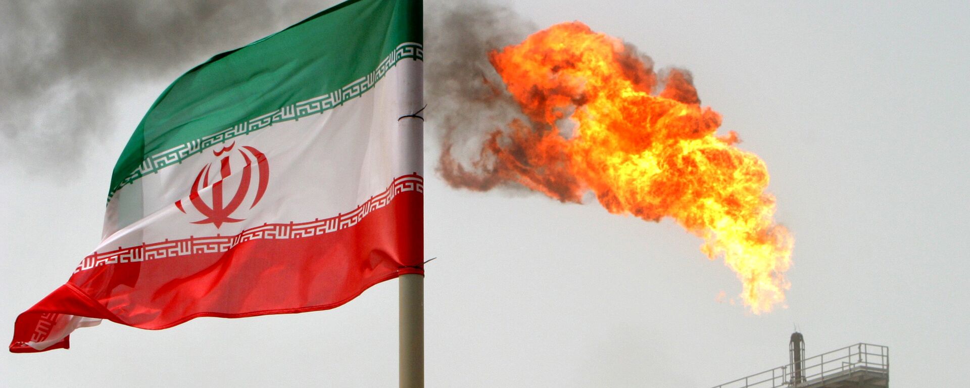La bandera de Irán con una llama de gas en una plataforma de producción de petróleo al fondo - Sputnik Mundo, 1920, 21.02.2022