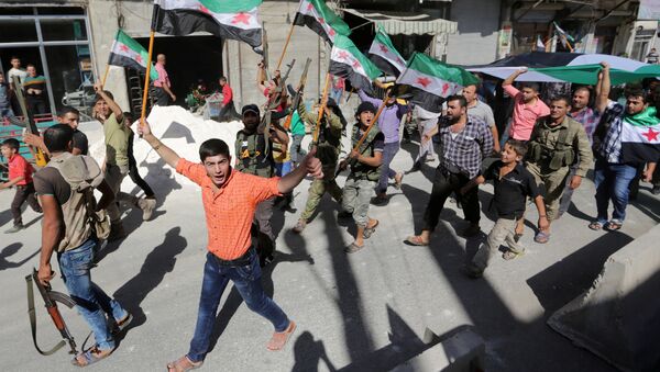 Militantes rebeldes y ciudadanos sirios con las banderas de la oposicón durante una protesta - Sputnik Mundo