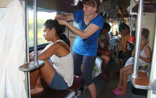 En un vagón 'platzkart', una rusa trenza el cabello de Camila, una de las viajeras brasileñas - Sputnik Mundo