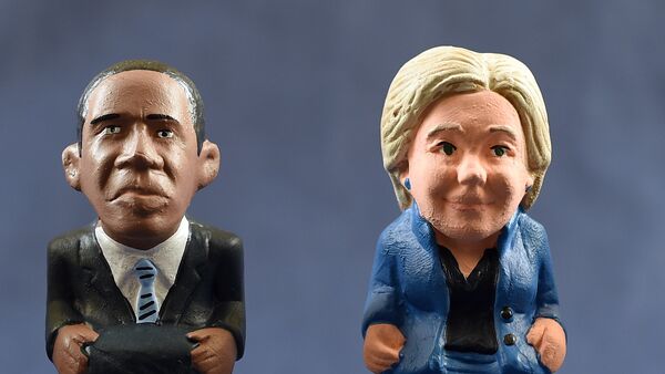A picture taken on September 26, 2016 shows ceramic figurines, called caganers (poopies), representing US president Barack Obama (L) and US Democratic presidential nominee Hillary Clinton ahead of the first campaign debate. Statuettes of well-known people defecating are a strong Christmas tradition in Northeastern Spanish region of Catalonia, dating back to the 18th century as Catalans hide 'caganers' in Christmas Nativity scenes and invite friends to find them. The figures symbolize fertilization, hope and prosperity for the coming year. - Sputnik Mundo