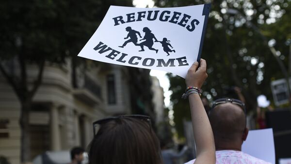 Mujer sostiene cartel de bienvenida a refugiados - Sputnik Mundo