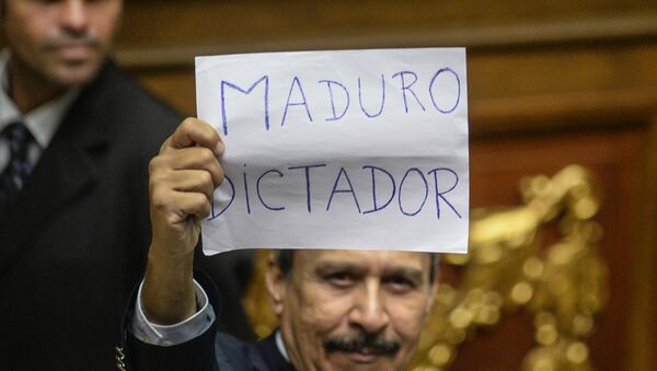 A Venezuelan opposition deputy holds up a sing reading  Maduro dictator during an extraoridinary session of the National Assembly, in Caracas on October 23, 2016. - Sputnik Mundo