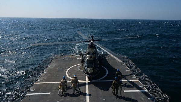 Romanian frigate Regina Maria personnel with the NATO Standing Maritime Group-2 maintain a helicoper which just landed on the heliport of the ship during a military drill on the Black Sea, 60km from Constanta city March 16, 2015 - Sputnik Mundo