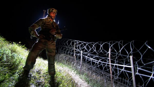 In this Dec. 22, 2013 photo, an Indian army soldier stands guard along barbed wire near the Line of Control (LOC), that divides Kashmir between India and Pakistan, at Krishna Ghati (KG Sector) in Poonch, 290 kilometers (180 miles) from Jammu, India - Sputnik Mundo