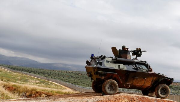 A Turkish soldier on armoured military vehicle patrols the border between Turkey and Syria, near the southeastern village of Besarslan, in Hatay province - Sputnik Mundo