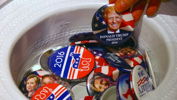 A guest at an event called the U.S. Presidential Election Watch, organised by the U.S. Consulate, reaches for a badge from out of a hat displaying photographs of Republican candidate Donald Trump and Democratic candidate Hillary Clinton, in Sydney, Australia - Sputnik Mundo