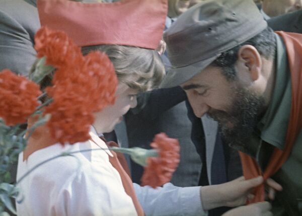 Pionera soviética cuelga un pañuelo rojo (símbolo de los pioneros) en el cuello de Fidel Castro. - Sputnik Mundo