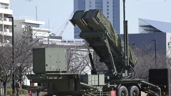 A man walks past a PAC-3 Patriot missile unit deployed for North Korea's rocket launch at the Defense Ministry in Tokyo. Japan has deployed PAC-3 missile batteries in the heart of Tokyo to defend its airspace from incoming rocket debris. South Korea is reportedly mobilizing two Aegis-equipped destroyers - Sputnik Mundo