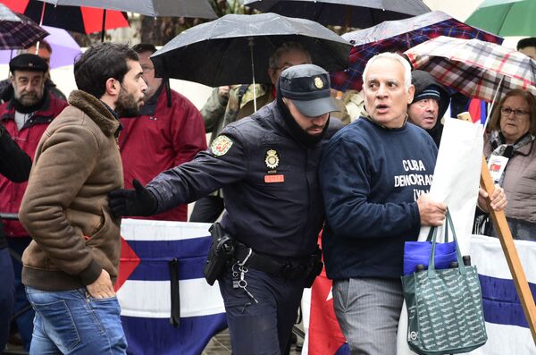 Oficial de la policía separa a los simpatizantes y oponentes de Fidel Castro en Madrid, España. - Sputnik Mundo