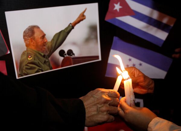 Personas ponen velas al pie de las fotos de Fidel, como parte del tributo al líder de la Revolución cubana en Honduras. - Sputnik Mundo