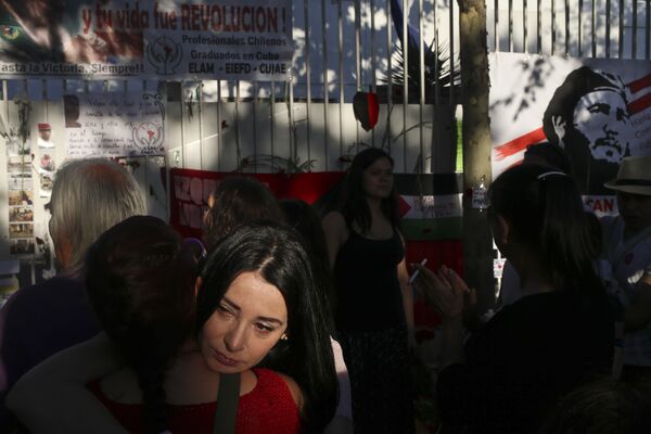 Mujeres lloran la muerte de Fidel Castro frente a la embajada de Cuba en Santiago de Chile. - Sputnik Mundo