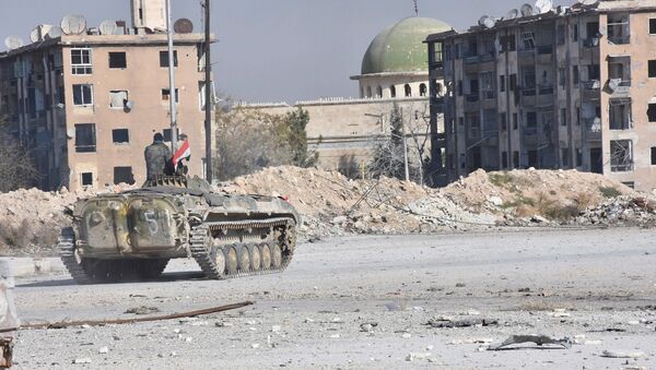 A Syrian government soldier rides a military vehicle near a mosque, after taking control of Aleppo's Al-Haidariya neighbourhood, Syria in this handout picture provided by SANA - Sputnik Mundo