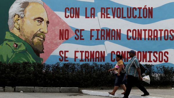 Gente caminando frente a un graffiti del fallecido presidente cubano Fidel Castro en Santiago de Cuba, Cuba 3 de diciembre de 2016. - Sputnik Mundo