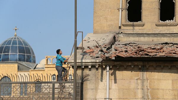 A Christian employee at Cairo’s Coptic Cathedral checks for damage from the blast after an explosion inside the cathedral in Cairo - Sputnik Mundo