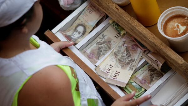 A cashier receives Venezuelan bolivar notes at a market in downtown Caracas, Venezuela - Sputnik Mundo