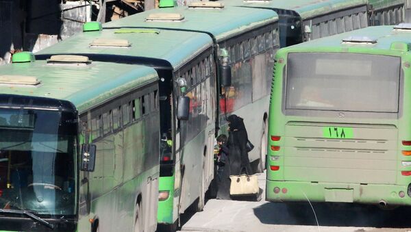 People get on buses to be evacuated from al-Sukkari rebel-held sector of eastern Aleppo, Syria - Sputnik Mundo