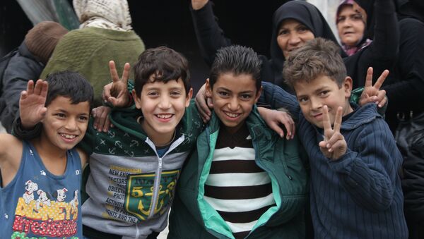 Niños que celebran la liberación en Hanano, este de Alepo - Sputnik Mundo