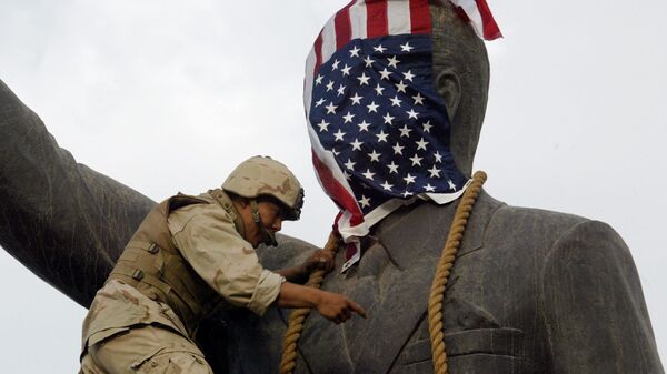 A US Marine covers the head of a statue of Iraqi President Saddam Hussein with the US flag before pulling it down in Baghdad's al-Fardous (paradise) square 09 April 2003 as the marines swept into the Iraqi capital and the Iraqi leader's regime collapsed. - Sputnik Mundo