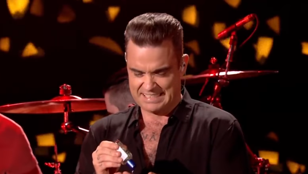 Robbie Williams se desinfecta las manos después de tocar a sus fans - Sputnik Mundo