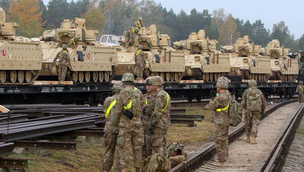 Members of the US Army 1st Brigade, 1st Cavalry Division, unload heavy combat equipment including Bradley Fighting Vehicles at the railway station near the Rukla military base in Lithuania, on October 4, 2014 - Sputnik Mundo