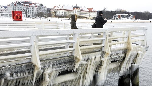 People walk along ice covered pier in Sopot, Poland - Sputnik Mundo