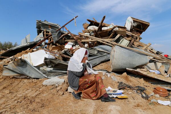 Un mujer árabe llora sobre las ruinas de su vivienda, demolida por buldóceres israelíes en la aldea de Umm al Hiran en el sur de Israel. 18 de enero de 2017. - Sputnik Mundo