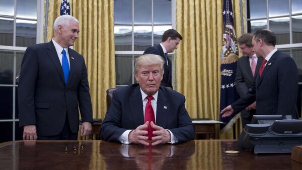 US President Donald Trump (C) waits at his desk before signing confirmations for James Mattis as US Secretary of Defense and John Kelly as US Secretary of Homeland Security, as Vice President Mike Pence (L) and White House Chief of Staff Reince Priebus (R) look on, in the Oval Office of the White House in Washington, DC, January 20, 2017 - Sputnik Mundo