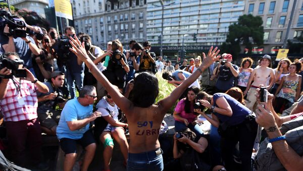 A woman poses topless with the words I am free written on her back during a protest in response to a recent incident on an Argentine resort beach between police and topless sunbathers, in downtown Buenos Aires - Sputnik Mundo