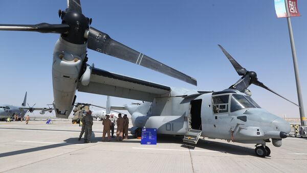 US soldiers stand in the shade of the wing of a Bell Boeing V-22 Osprey, a US multi-mission, tiltrotor military aircraft, displayed at the Dubai Airshow on November 8, 2015 - Sputnik Mundo