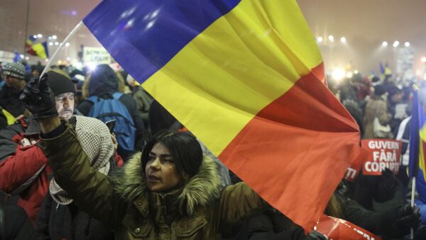 A woman waves a Romanian flag during a protest of thousands against their government in Bucharest, Romania, February 6, 2017 - Sputnik Mundo