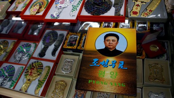 Un álbum de sellos con un retrato del difunto líder norcoreano Kim Jong-il en una exposición en una tienda de suvenires en Dandong - Sputnik Mundo