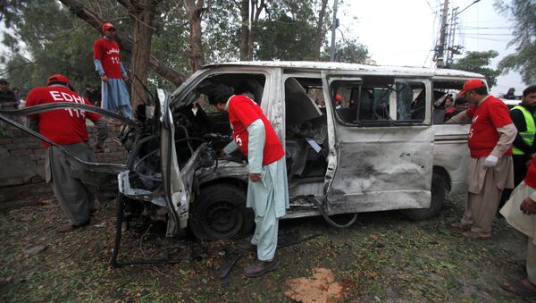 Volunteers search for remains in a vehicle at the scene of a bomb attack in Peshawar, Pakistan - Sputnik Mundo