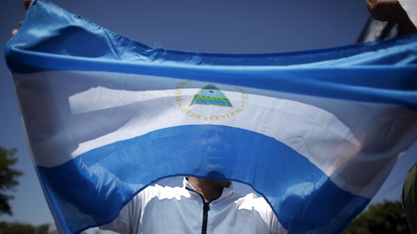 Hombre sostiene la bandera de Nicaragua - Sputnik Mundo