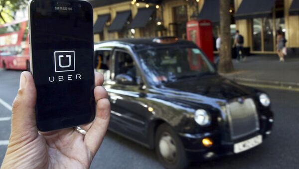 A photo illustration shows the Uber app logo displayed on a mobile telephone, as it is held up for a posed photograph in central London, Britain August 17, 2016. - Sputnik Mundo