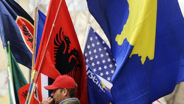 Un hombre vendiendo banderas de Kosovo y Albania - Sputnik Mundo