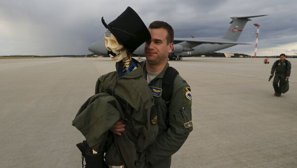 Eric Kordus, a F-22 Raptor fighter jet pilot of the 95th Fighter Squadron from Tyndall, Florida, carries Mr. Bone, the squadron's mascot consisting of a dressed-up plastic skeleton with a stovepipe hat and a moustache, after a refuelling mission of a KC-135 Stratotanker from the NATO airbase of Aemari, Estonia to Spangdahlem, Germany September 4, 2015 - Sputnik Mundo