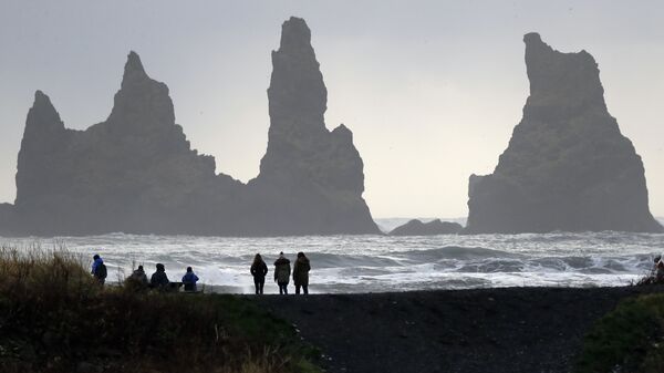 People walk on the black sanded beach in Vik, Iceland, near the Volcano Katla - Sputnik Mundo