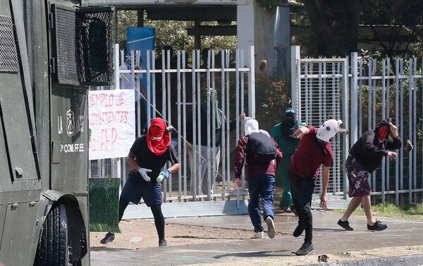 Manifesantes tiran piedras contra los policías durante el Día del Joven Combatiente en Chile - Sputnik Mundo