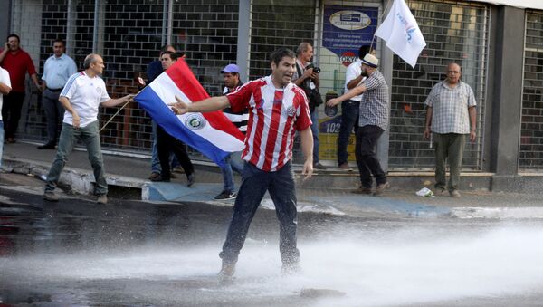 Protestors fight with the police during a demonstration against a possible change in the law to allow for presidential re-election in front of the Congress building in Asuncion, Paraguay - Sputnik Mundo